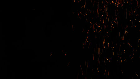 sparks and embers from campfire flying over black background