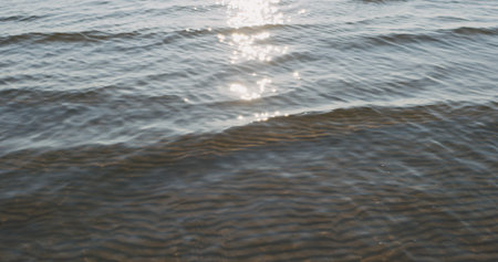 small waves on sandy sea beach on a sunny dayの写真素材