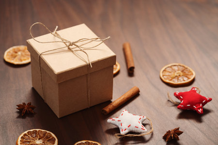 Christmas gift box from eco friendly paper wrapped with natural twine on wood table with natural decorationsの写真素材