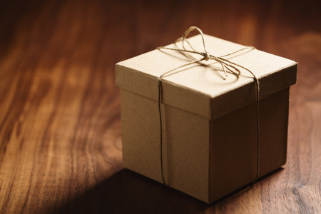 brown paper gift box on wood table in front of window with copy spaceの写真素材