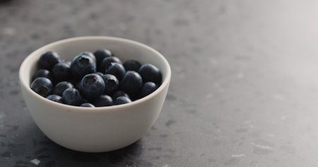 ripe blueberries in white bowl closeupの写真素材