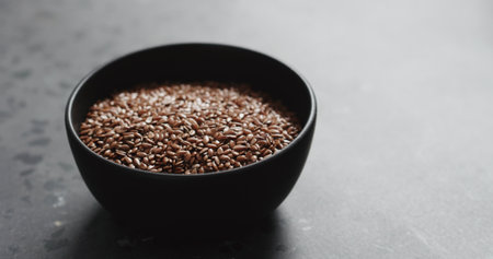 flaxseed in black bowl on terrazzo countertop with copy spaceの写真素材