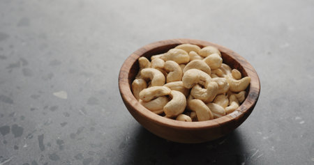 cashew nuts in olive bowl on terrazzo countertopの写真素材