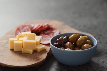 olives, salami and cheese on concrete countertop