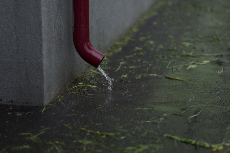 Purple rain drain pipes with water flowing from it