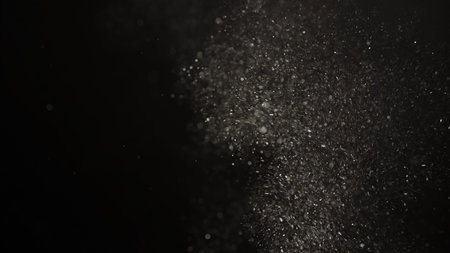Slow motion real dust flow over dark background