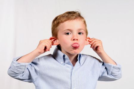 Cute little blonde boy sticking out tongue