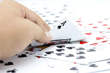Closeup photos that focuses on the ace card of spade in the hand,on the background from the stack of...