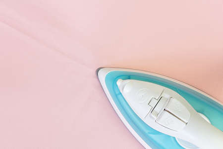 Electric iron on pink fabric (with clipping path)の写真素材