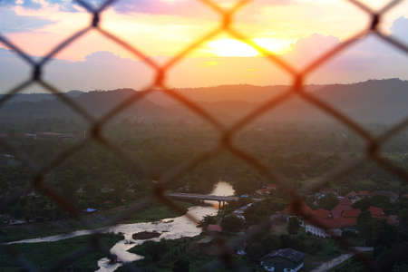 Abstract background mesh fence blurred on a  background of Beautiful scenery during time the sunset. The nature and the freedom conceptの写真素材