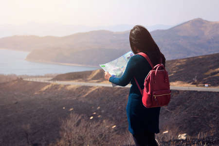 Traveler woman searching right direction on map at the mountain surrounded by beautiful natural to find attractions in Japan. Travel and active lifestyle conceptの写真素材