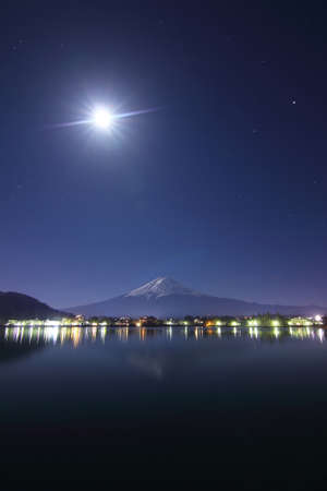 Beautiful scenery of the moon on night sky at Mountain Fuji in kawaguchiko lake of Japan.の写真素材