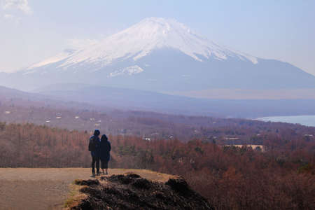 Couple travelers Man and Woman standing admire the beautiful nature of Mt. Fuji in Japan. Travel and Attractions Concept.のeditorial素材