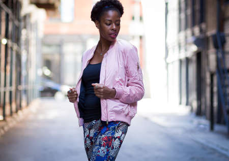 Portrait of young black woman in dark city street, photographed in NYC in September
