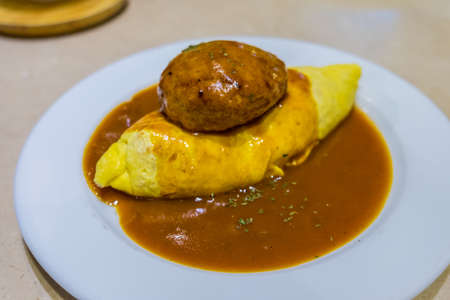 Demiglace sauce omurice with hamburger on white plateの写真素材
