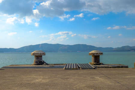 old concrete pier with ocean in blue sky