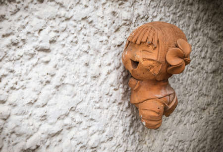 smily girl doll on the wallの写真素材