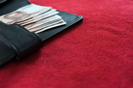 selective focus. black wallet and Thai banknote on red background, thai money on red background