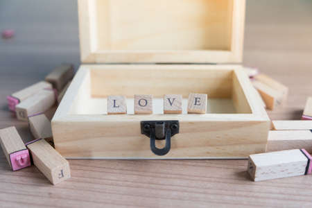 Opende chest ,alphabet rubber stamp in wooden box that arranged word "love"の写真素材