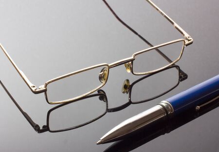 Glasses and a blue fountain pen.の写真素材