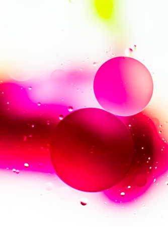 Closeup shot of oil on water with a pink background
