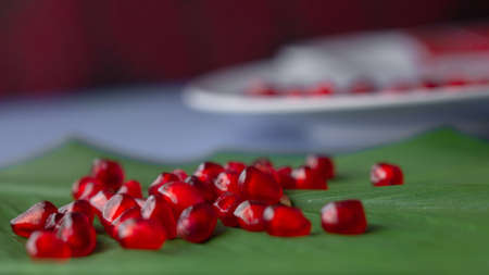 Pomegranate fruit seeds stacked together on a green leafの写真素材
