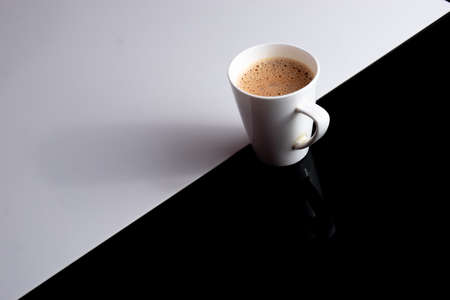 A cup of tea with lots of working space around on a black and white backgroundの写真素材