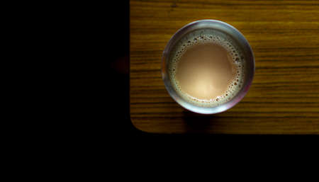 Coffee in a steel tumbler on a wooden tableの写真素材