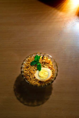 Tasty homemade egg biriyani in a bowl on the wooden tableの写真素材