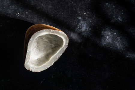 Dry coconut on a black background with artistic lightingの写真素材