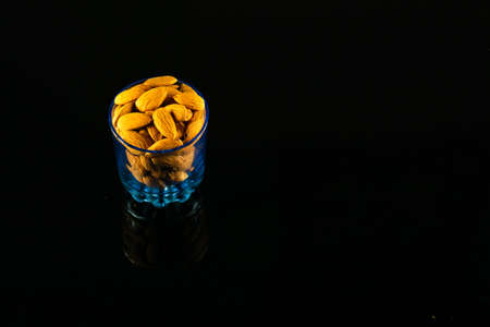 Protein-rich Raw Badam stacked in a glass on a dark tableの写真素材