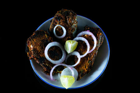Healthy tasty and spicy fish fry kept on a white plate ready to be served