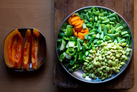 Fresh vegetable cut pieces in a plate on a wooden backgroundの写真素材