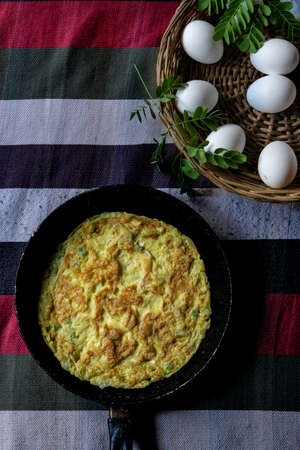 Healthy omelet in a frying pan with partial eggs visible