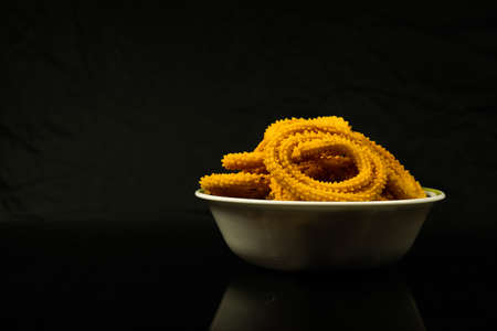 Homemade fried food in a bowl placed on a black background