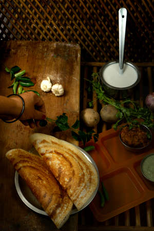 Homemade delicious and tasty dosa with selective focus and lighting on a cane backgroundの写真素材