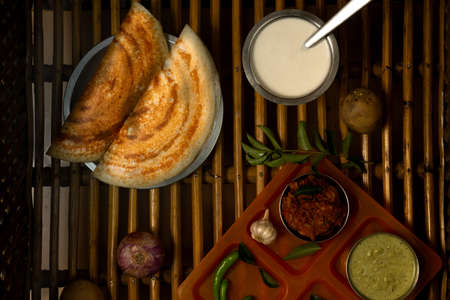 Homemade delicious and tasty dosa with selective focus and lighting on a cane background