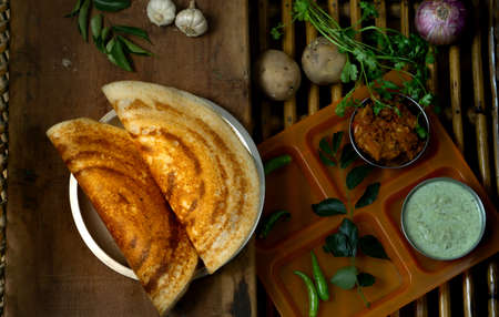Homemade delicious and tasty dosa with selective focus and lighting on a cane backgroundの写真素材