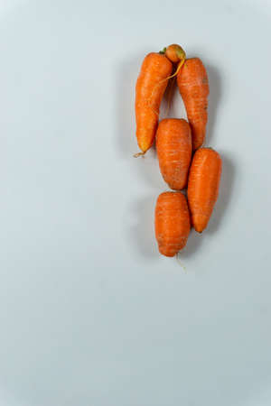 Fresh uncooked raw red carrots stacked together on a white background with copy spaceの写真素材