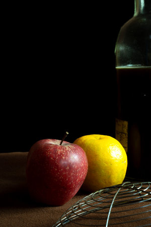 An apple and moosambi fruit placed on a brown backgroundの写真素材