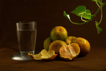 Fresh vitamin rich juicy oranges on a brown backgroundの写真素材
