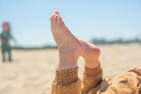 bare children's feet on the beach. children's feet close-upの写真素材
