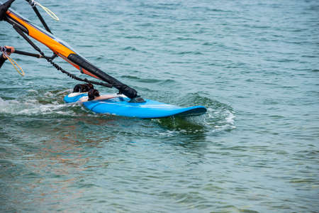 Windsurfing details, blue Board. A windsurfer rides on the seaの写真素材