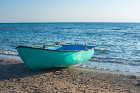 Fishing boat on the beach . Boat ,turquoise with oarsの写真素材