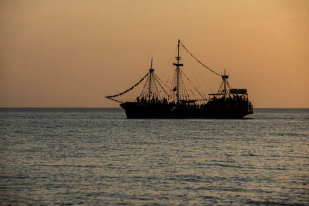 Beautiful sunset over the sea. Sailboat in the bay.
