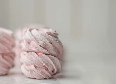 Meringue zephyr marshmallows on a light background. Pink sweet homemade marshmallow. meringue on...