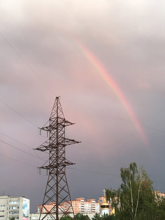 rainbow and power line support, rainbow in the city above the housesの写真素材