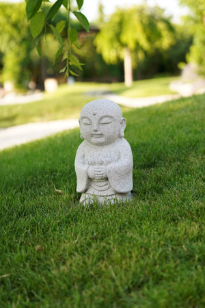 Japanese garden in Krasnodar Park. KRASNODAR, RUSSIA - JUNE 7, 2025: small stone sculpture of Buddha on a green lawnのeditorial素材