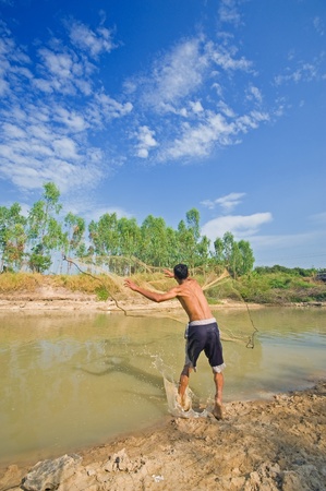 A man throw fishing net in lake の写真素材