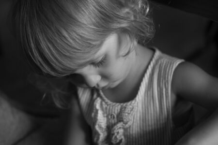 Little girl looking in camera and posing on a background of interior cafe.の写真素材